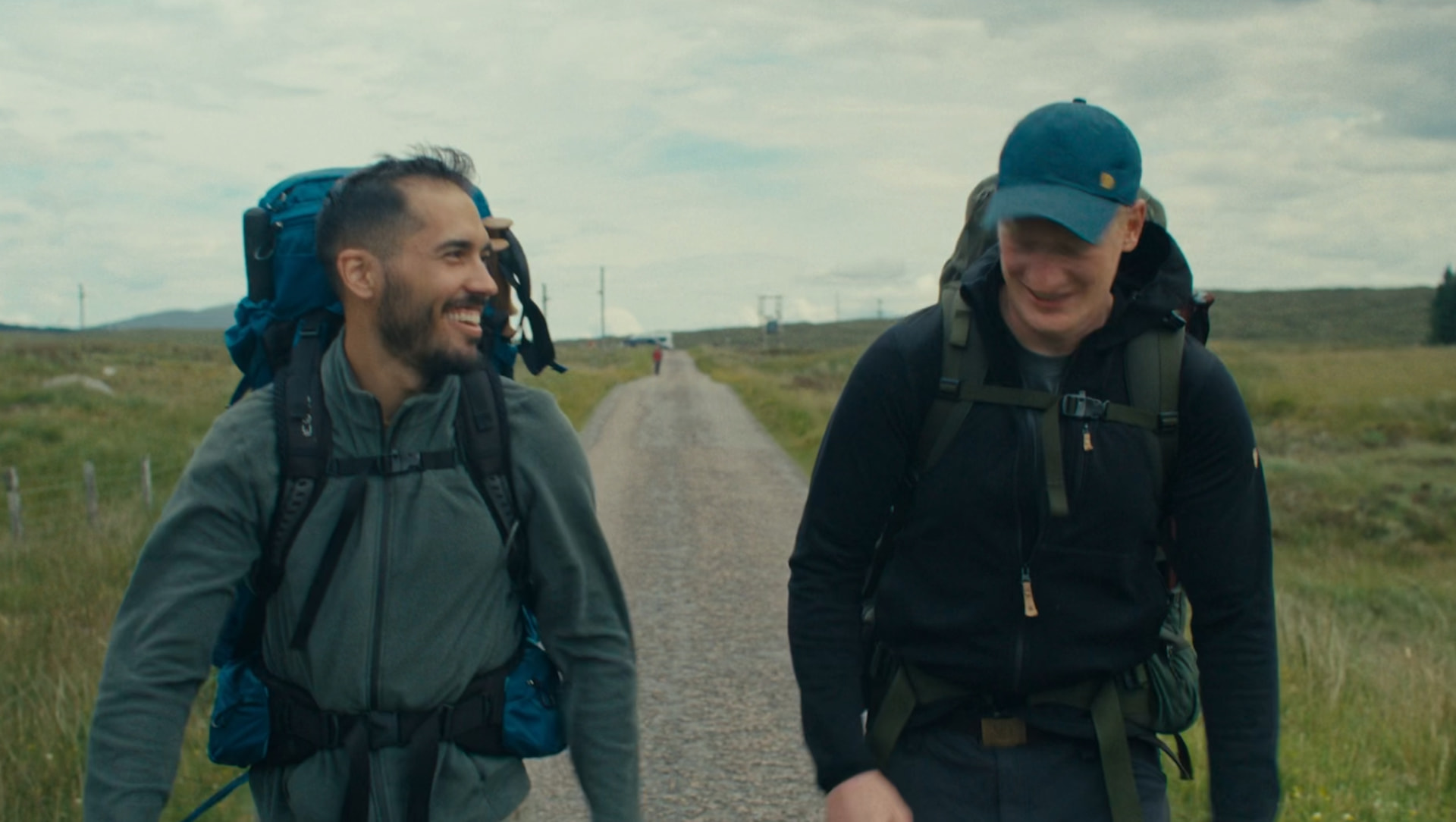 Still from The North — two hikers walking a remote road